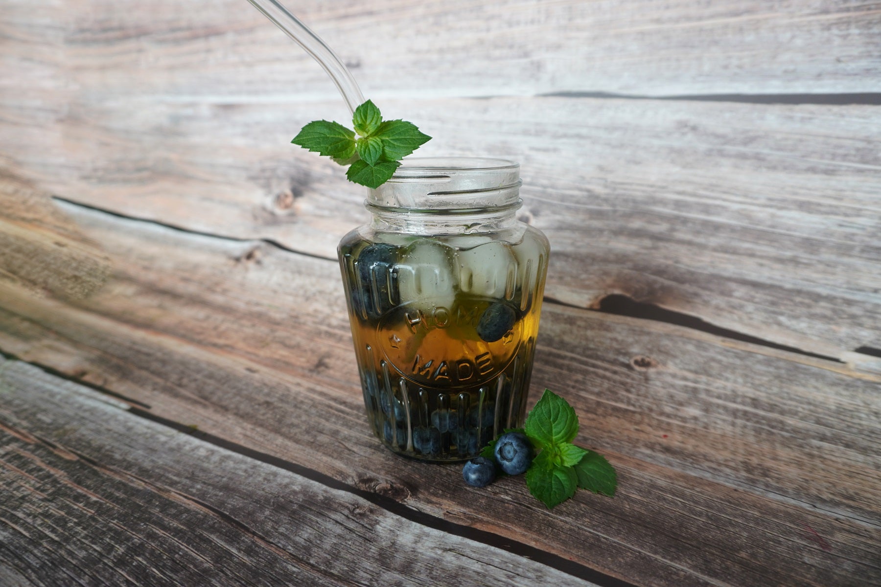 Blaubeer-Eistee in einem Glas mit Pfefferminz-Deko